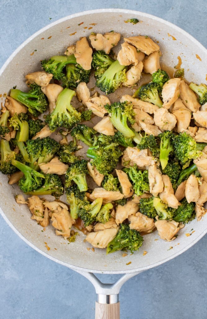 Easy Chicken and Broccoli Stir Fry cooked in a light grey pan on a grey background
