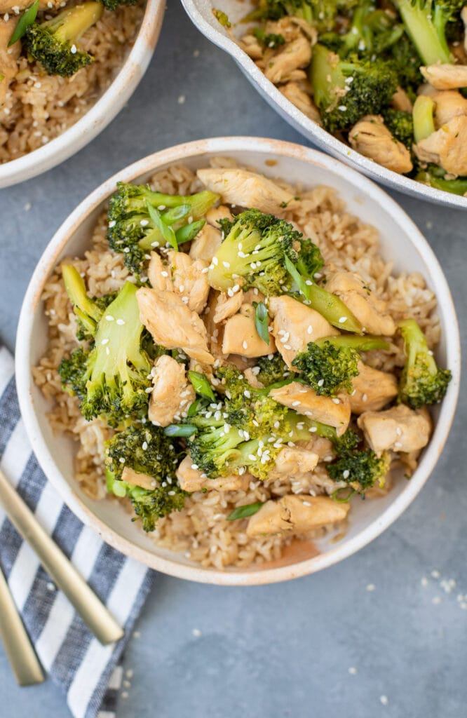 A close up of chicken broccoli stir fry in a bowl on a grey background