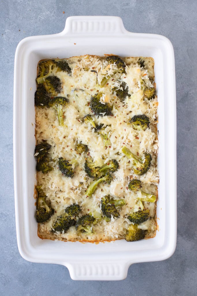 Cheesy Chicken & Rice Casserole in a white dish on a grey background after being baked