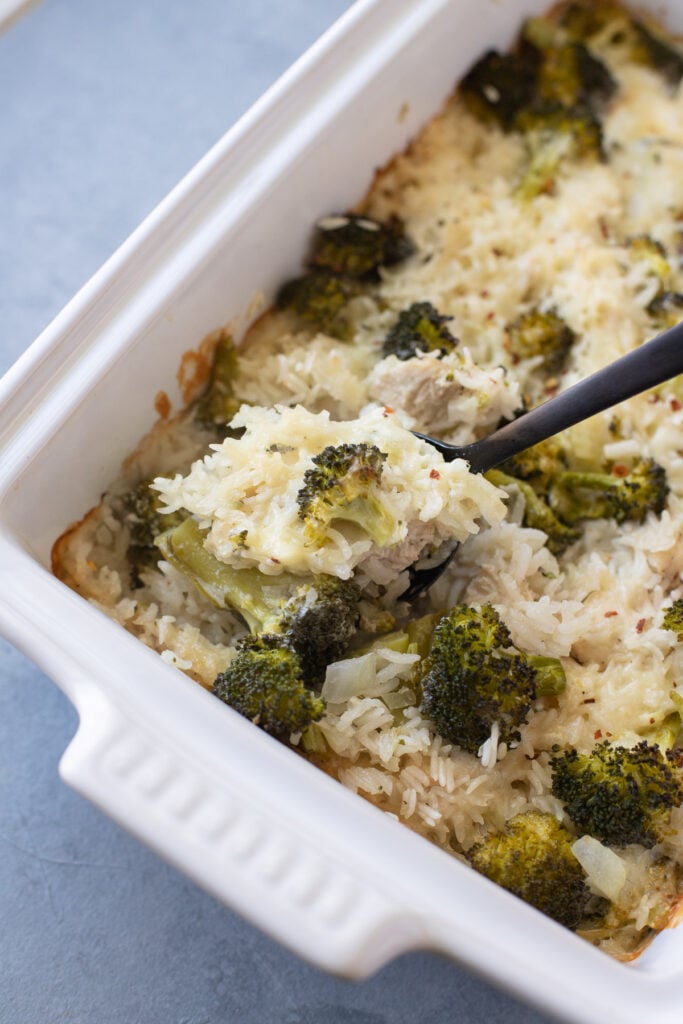 A spoon scooping out a serving of easy chicken broccoli rice casserole