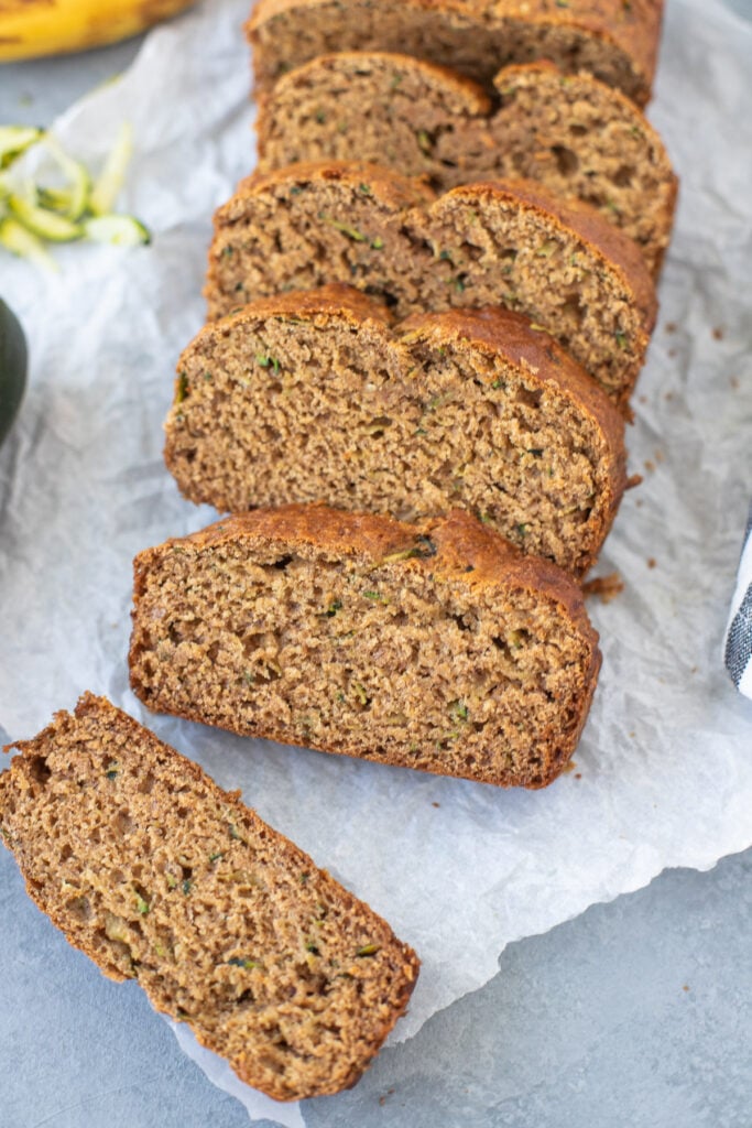 Zucchini Banana Bread Recipe sliced on a piece of parchment paper