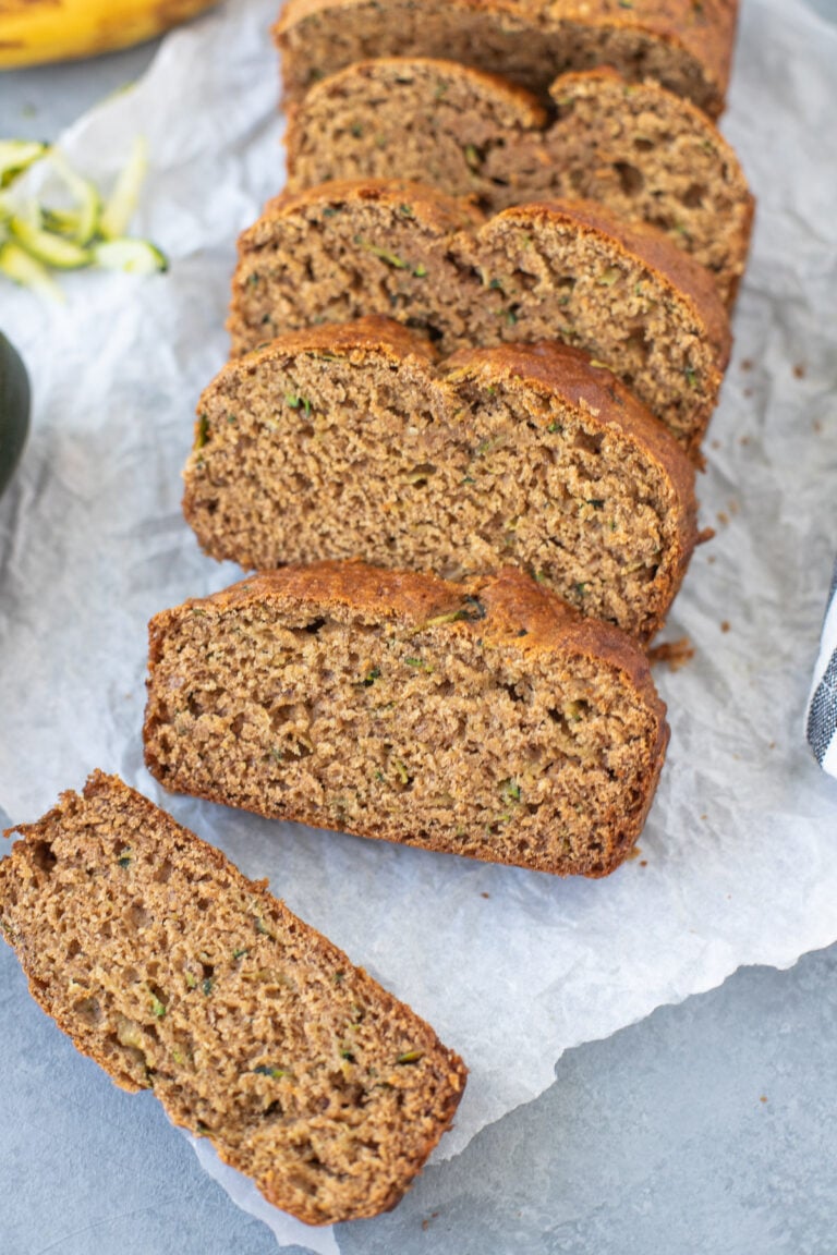 Zucchini Banana Bread Recipe sliced on a piece of parchment paper