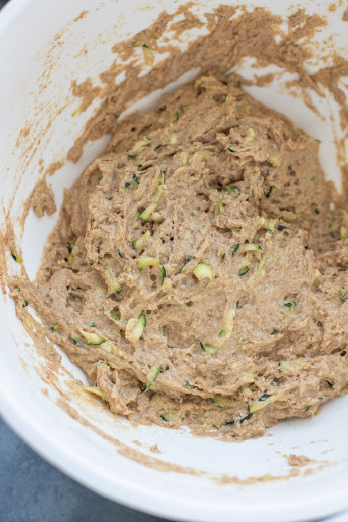 A bowl of healthy zucchini banana bread batter in a white bowl