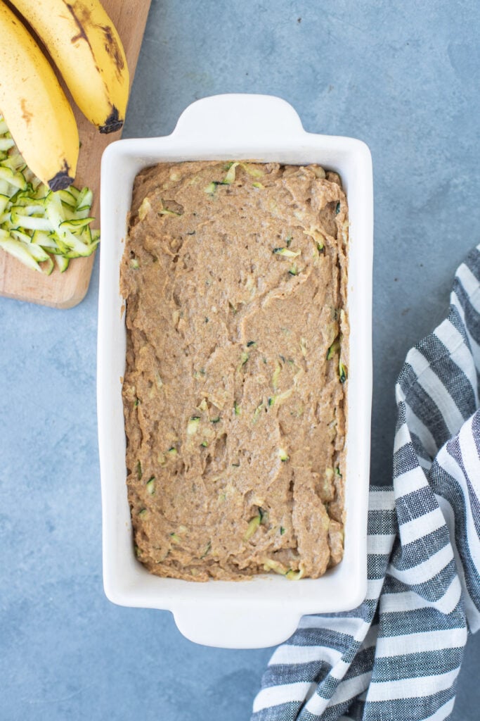 Zucchini Banana bread batter poured in a white loaf pan ready to be baked