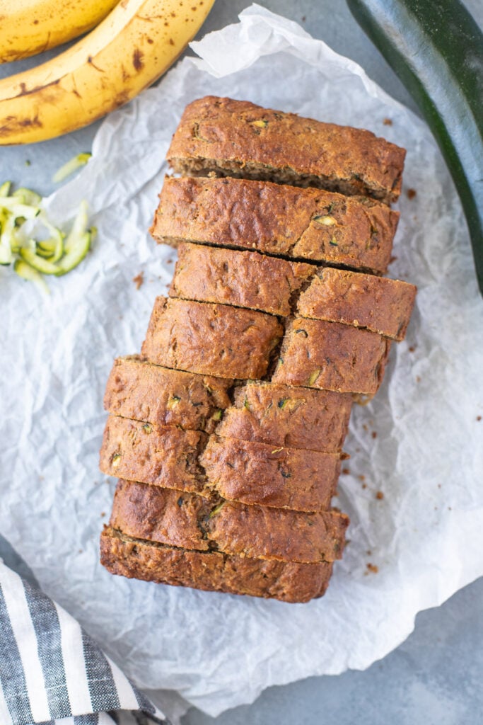 Banana Zucchini Bread sliced on a piece of white parchment paper