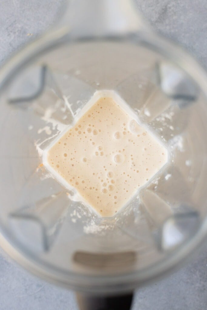 Ingredients in a blender blended up for a frozen banana smoothie