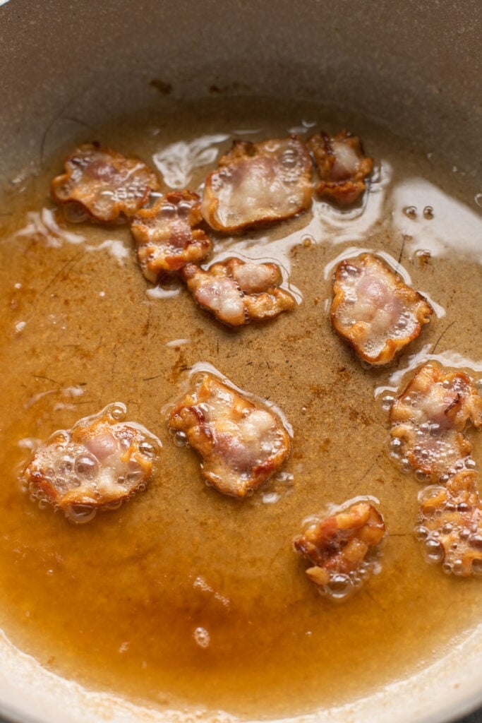 Butcherbox Bacon cooking in a pan of bacon grease