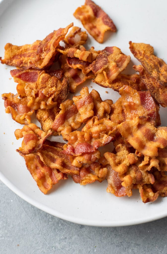 A close up of cooked bacon from butcherbox on a white plate