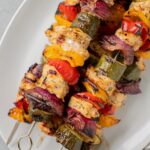Greek Chicken Kabobs Recipe on a white platter after coming off of the grill