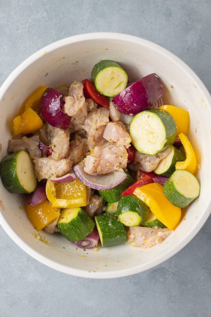 Greek chicken kabob components mixed together before being added to skewers