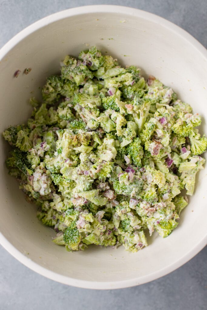 the best broccoli salad in a white biwl after being mixed together