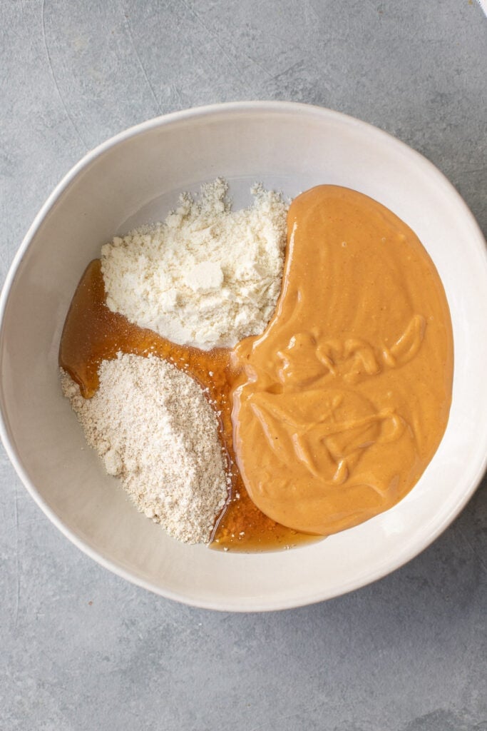 Ingredients for Protein Balls no bake in a white bowl before being mixed together