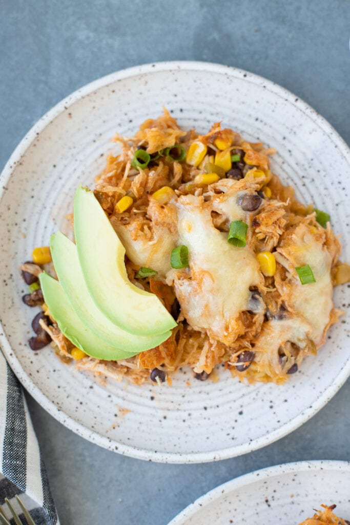 A close up of Healthy Spaghetti Squash Casserole on a white plate on a grey background