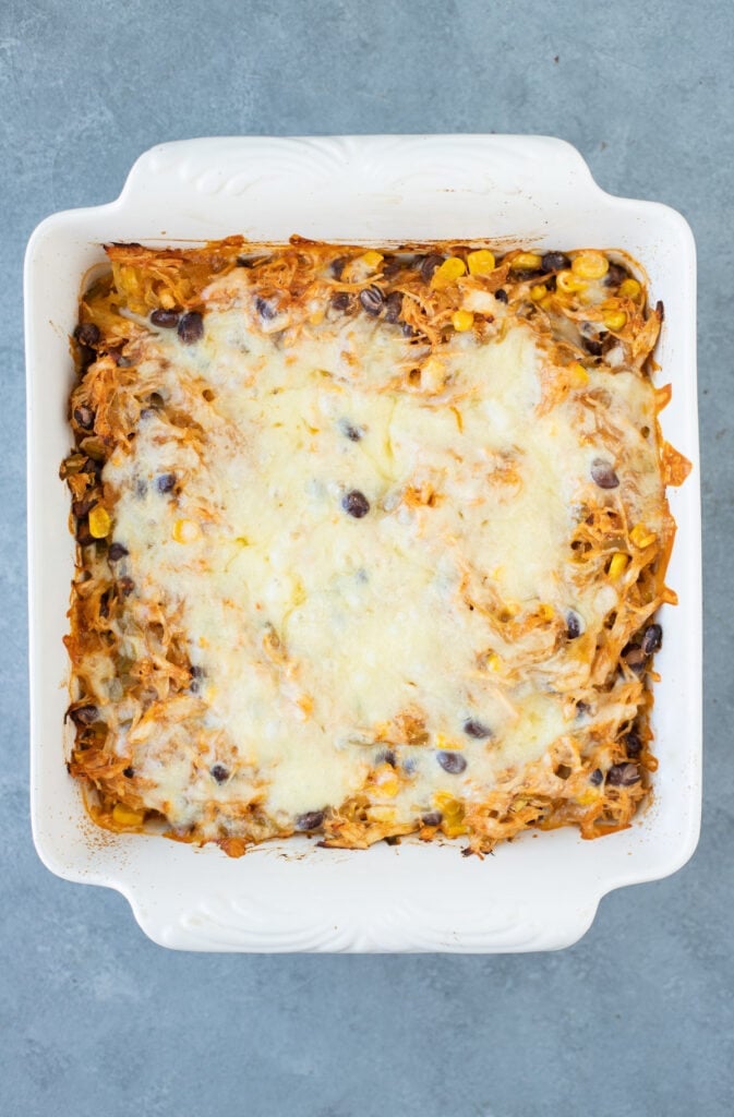 Freshly baked spaghetti squash casserole in a white baking dish on top of a grey background
