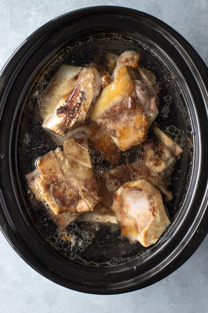 beef bone broth in the crockpot before it has been cooked