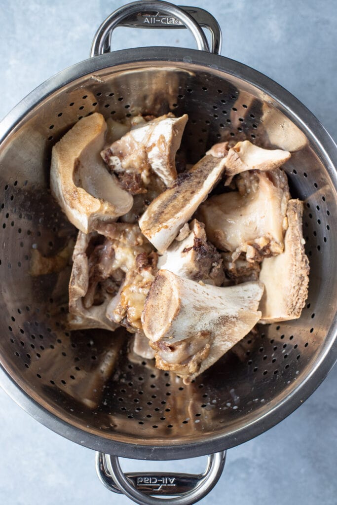 Beef Bone Broth in a strainer after it has been strained