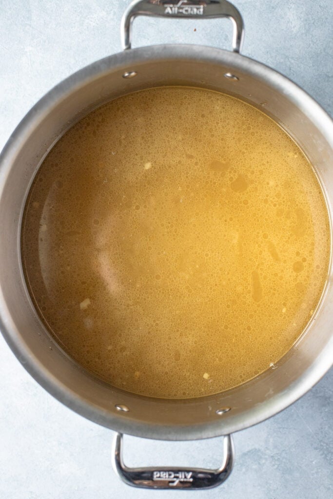 Beef bone broth strained in a silver pot