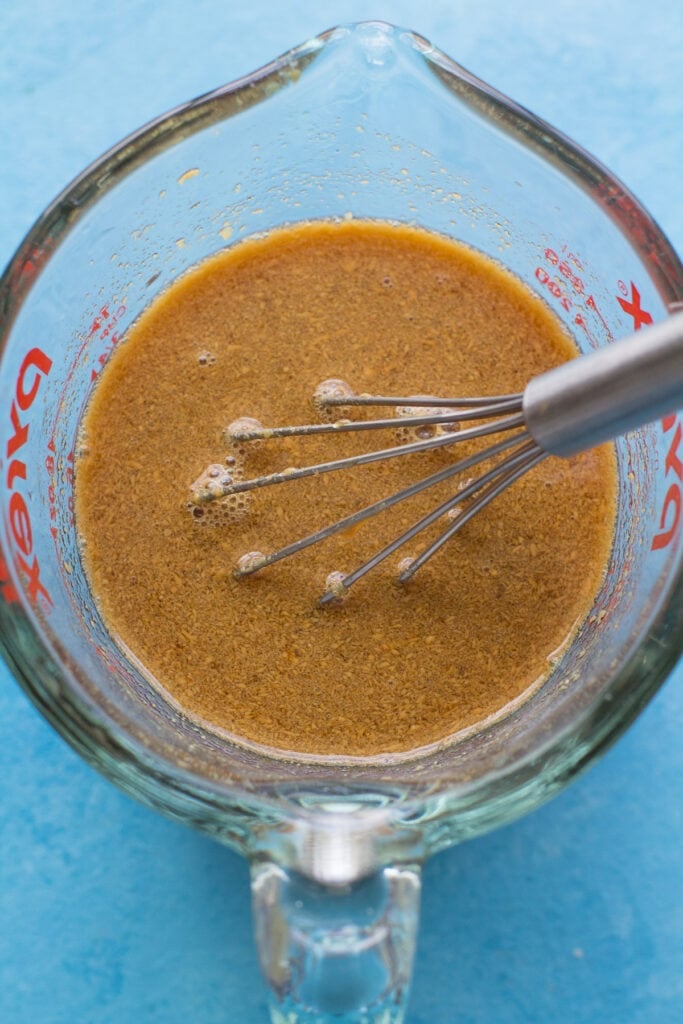 sauce for pad thai being whisked together in a glass container