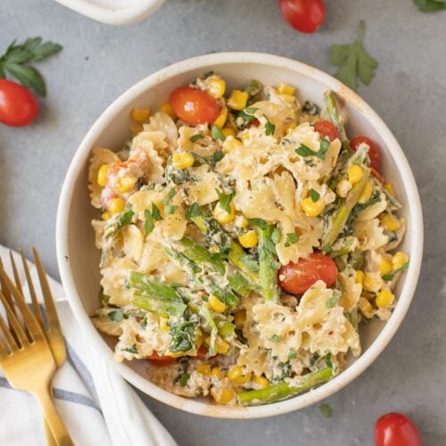 a close up of Goat Cheese pasta on a grey background with tomatoes scattered around the dish
