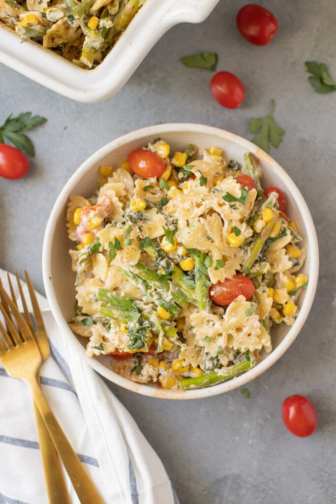a close up of Goat Cheese pasta on a grey background with tomatoes scattered around the dish