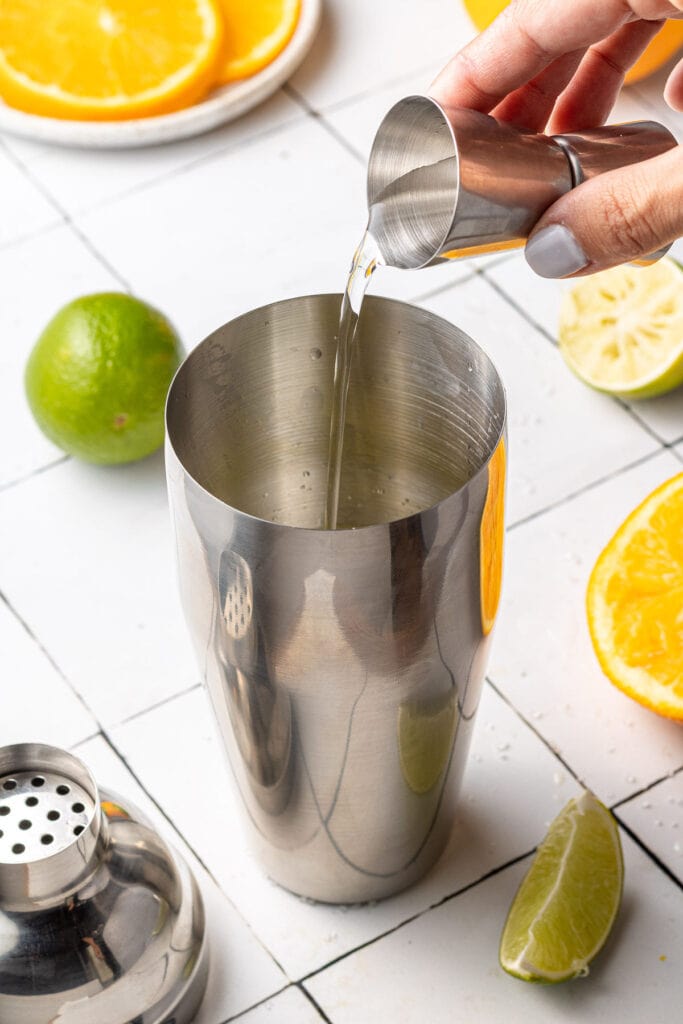 tequila being poured into a cocktail shaker for low calorie margaritas