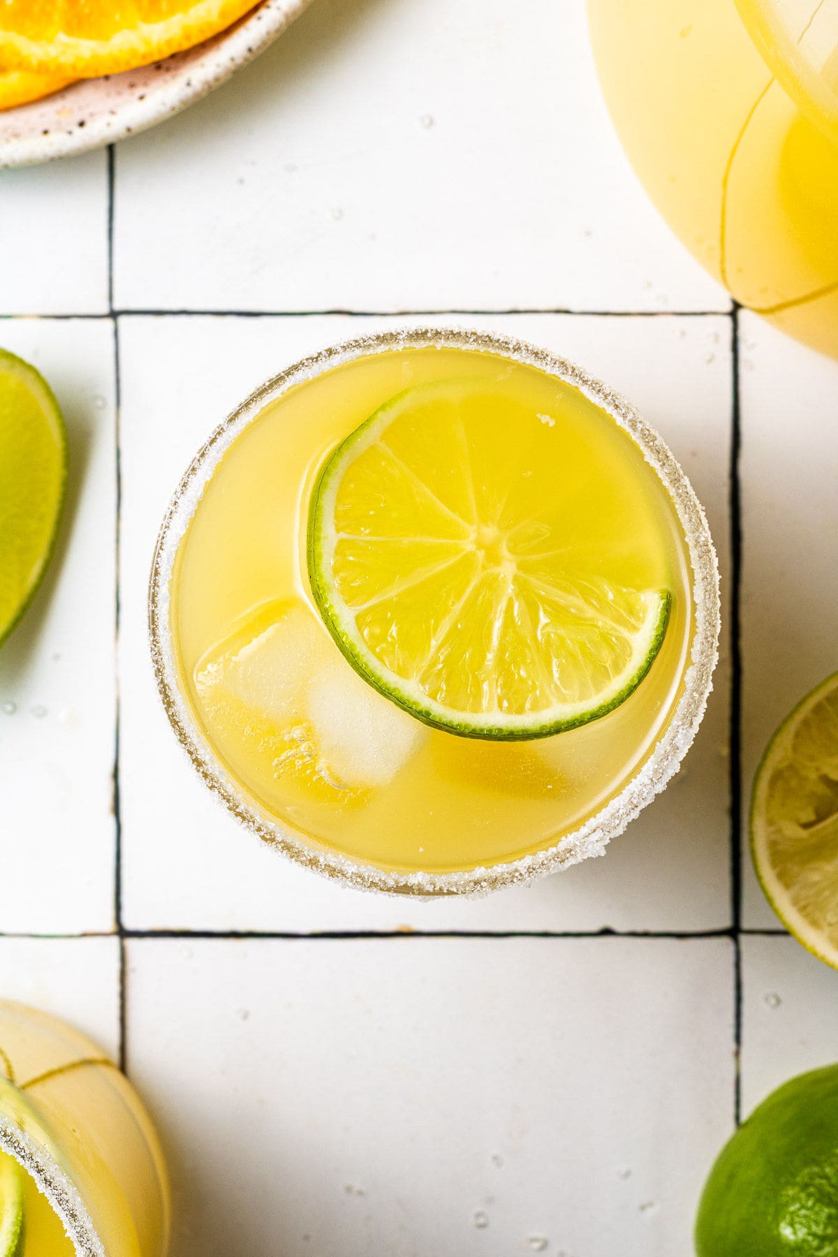 Overhead image of a lime slice floating in a cocktail served over ice.