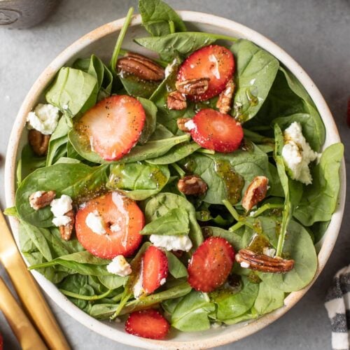 Strawberry Spinach Salad in a white bowl on a grey background