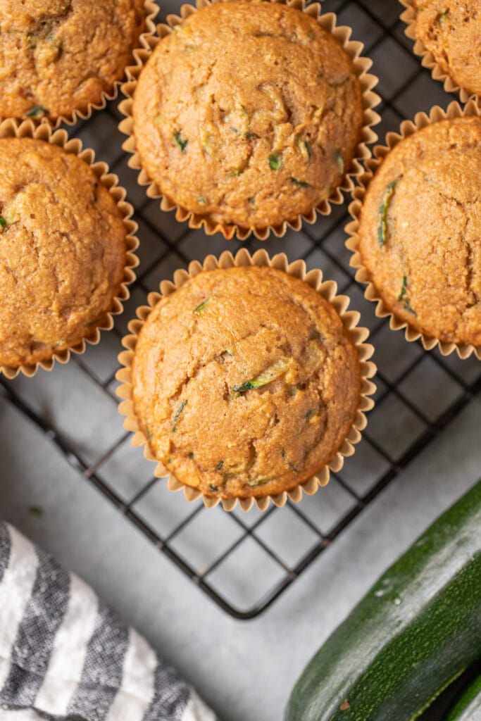 Healthy zucchini muffins on a cooling rack on a grey background