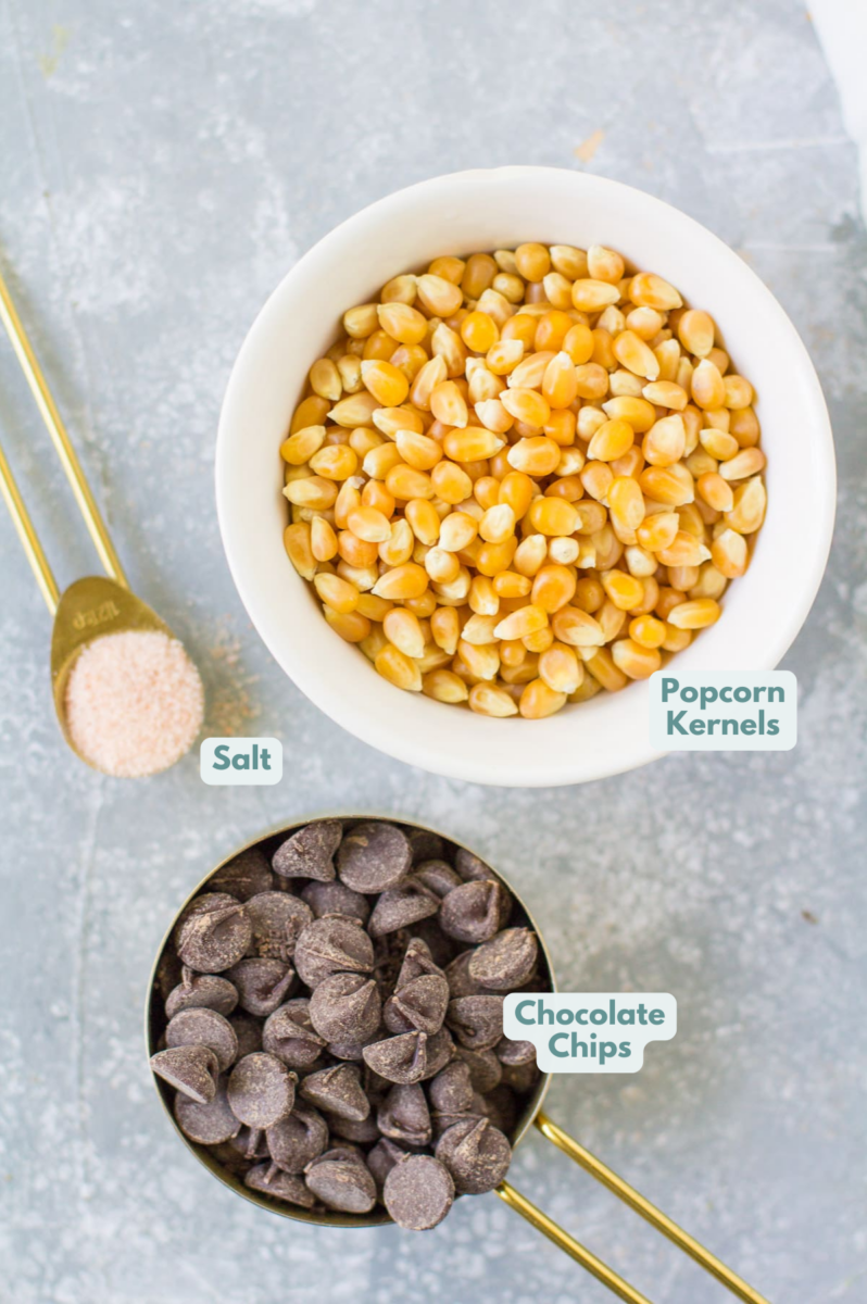 Ingredients for chocolate covered popcorn laid out on a grey background