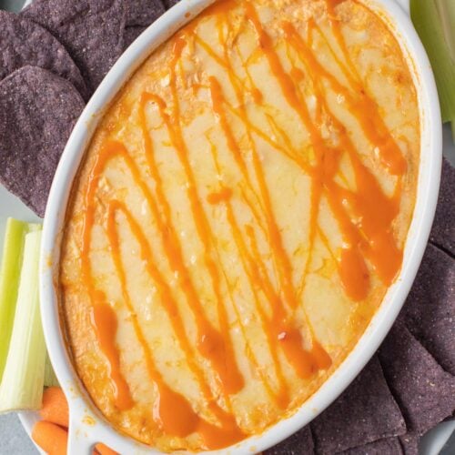 healthy buffalo chicken dip in a white dish fresh out of the oven.