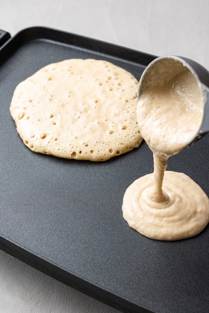 healthy pancake recipe batter being poured onto a griddle to cook