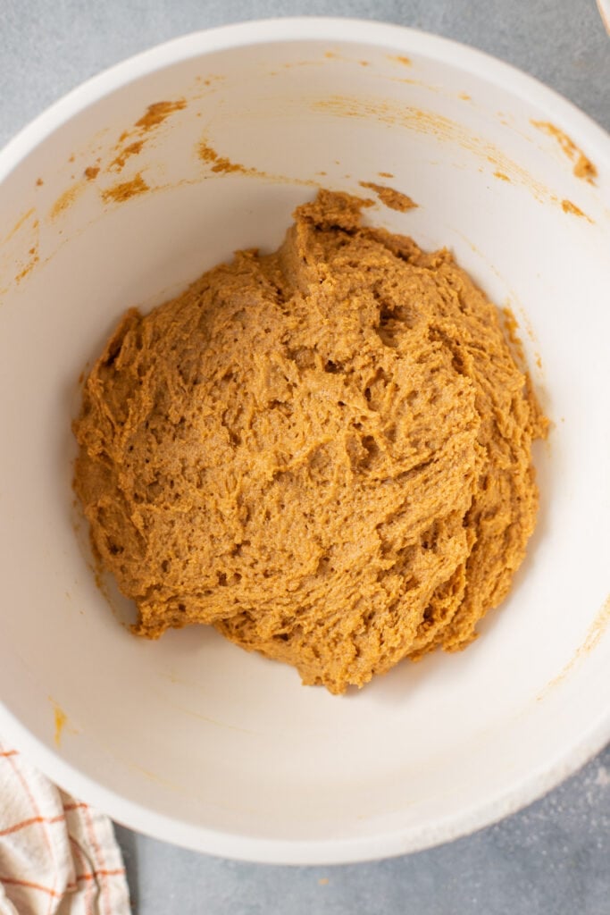 Batter for healthy pumpkin bread being mixed together in a white bowl