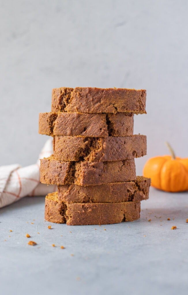 slices of pumpkin bread stacked on top of one another on a grey background