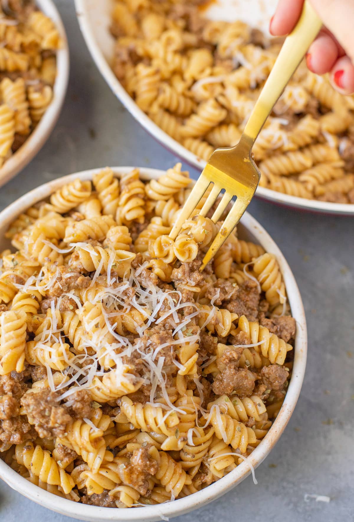 A forkful of healthy hamburger helper being removed from a bowl full of the dinner.