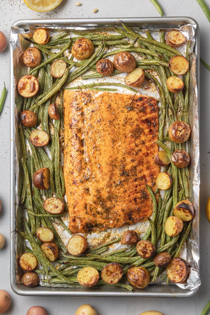 A close up of lemon salmon fresh out of the oven on a sheet pan