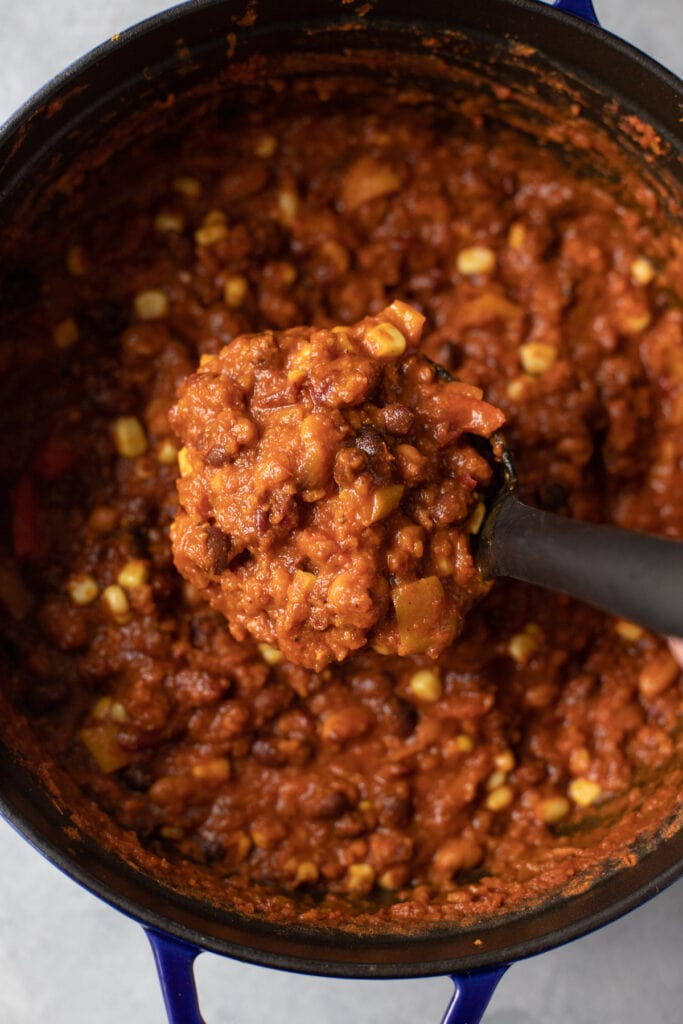 A close up of a ladle taking a scoop of easy vegetarian chili out of a pot