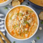 A close up of Buffalo Chicken Soup in a white bowl on a grey background
