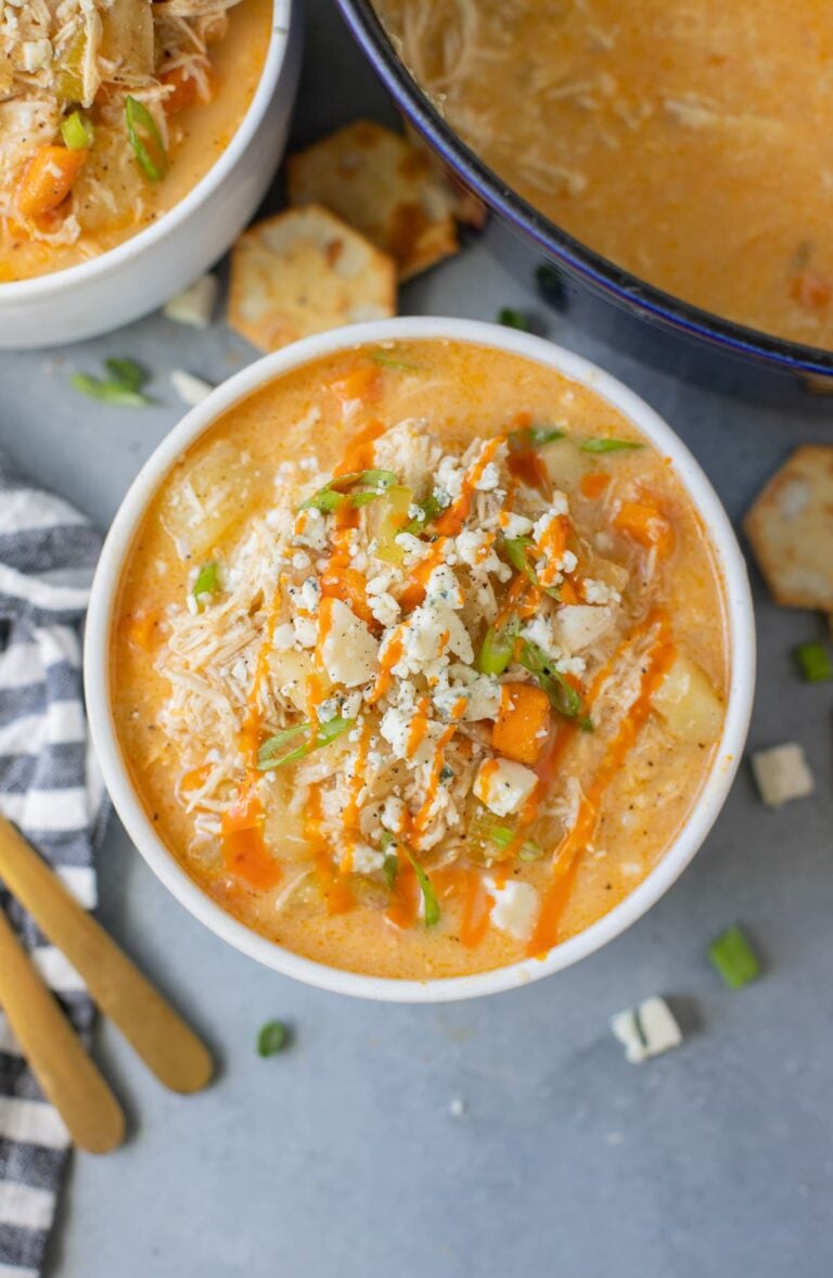 A close up of Buffalo Chicken Soup in a white bowl on a grey background