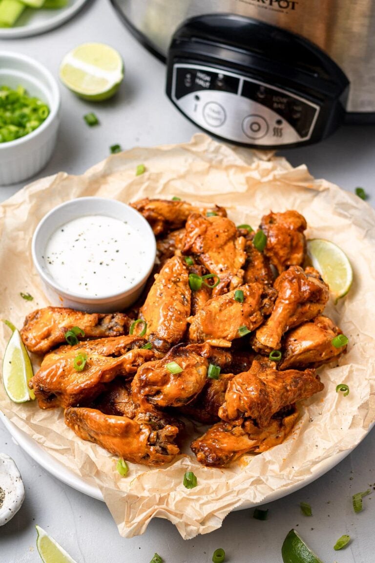 Crock Pot Chicken Wings on a platter with a slow cooker off to the side