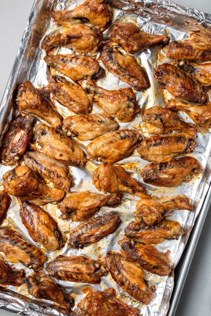 Crock pot chicken wings on a sheet pan that have been cooked in the oven