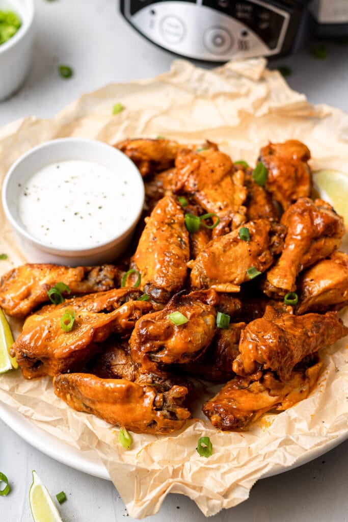 Crock Pot Chicken Wings on a platter with a slow cooker off to the side