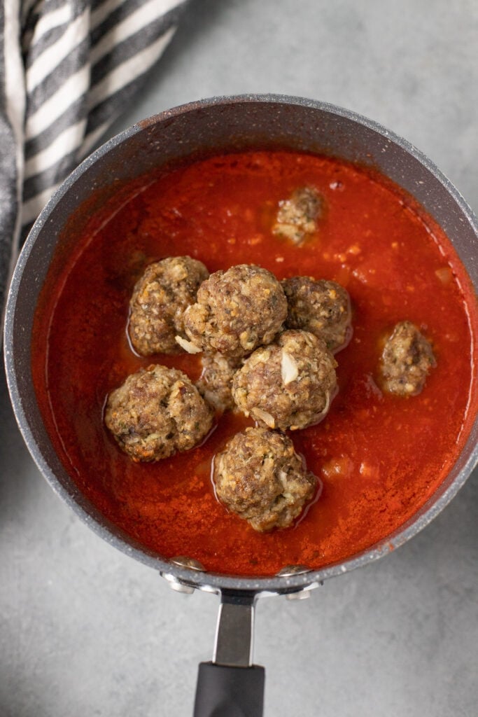 homemade Meatballs piled up in a big bowl of tomato sauce