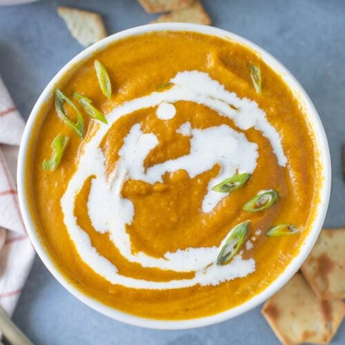 A bowl of Creamy Pumpkin Soup on a grey background