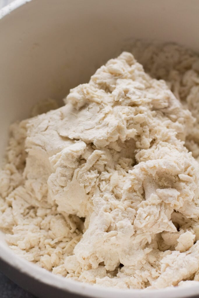 Shaggy dough in a large mixing bowl, viewed from overhead.