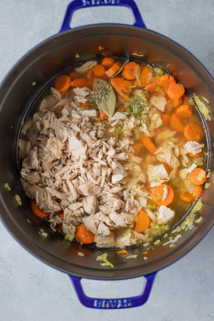 All ingredients for turkey noodle soup (except egg noodles) in a large pot