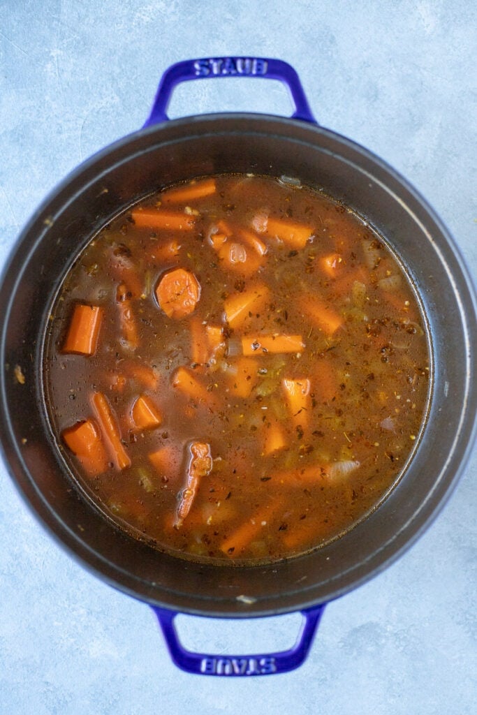 Carrot and ginger soup in a soup pot before being blended