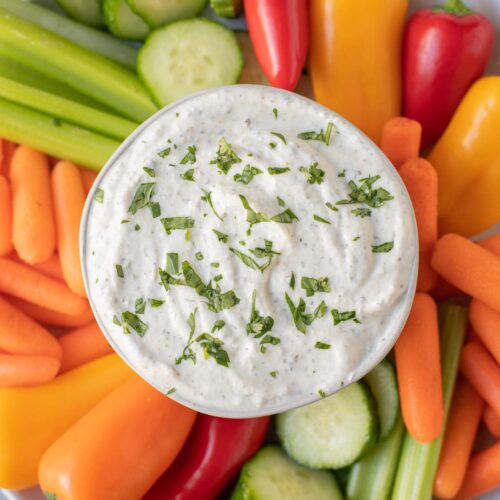 An overhead shot of greek yogurt veggie dip surrounded by veggies