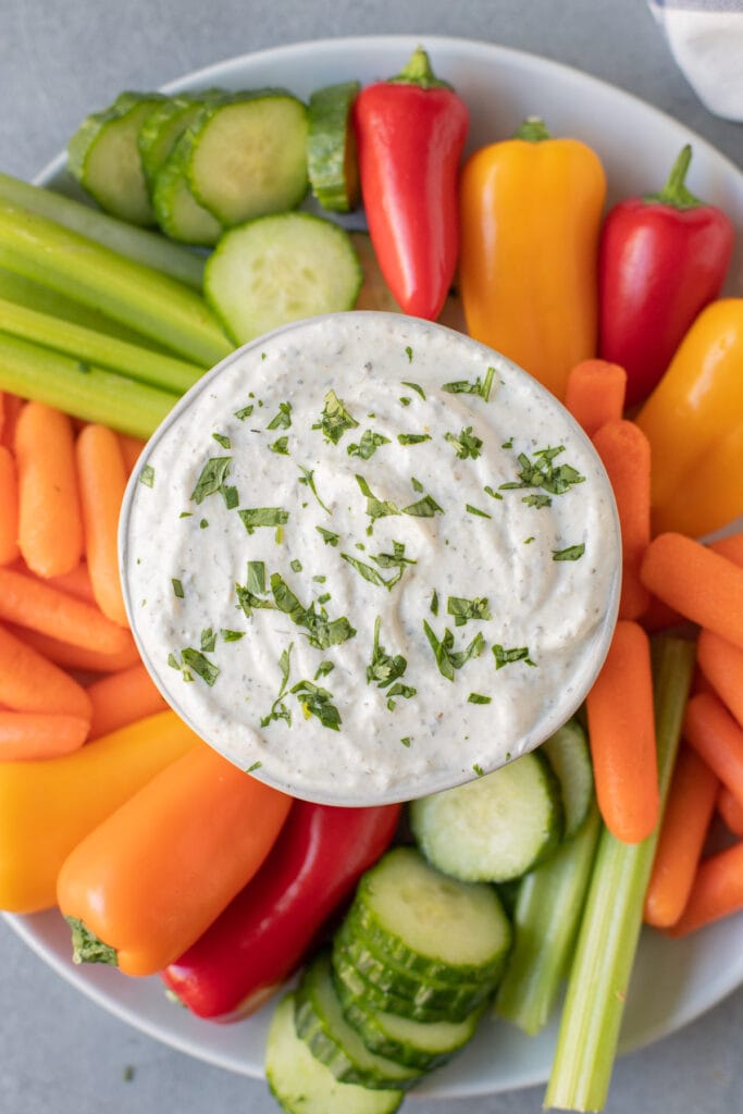 An overhead shot of greek yogurt veggie dip surrounded by veggies