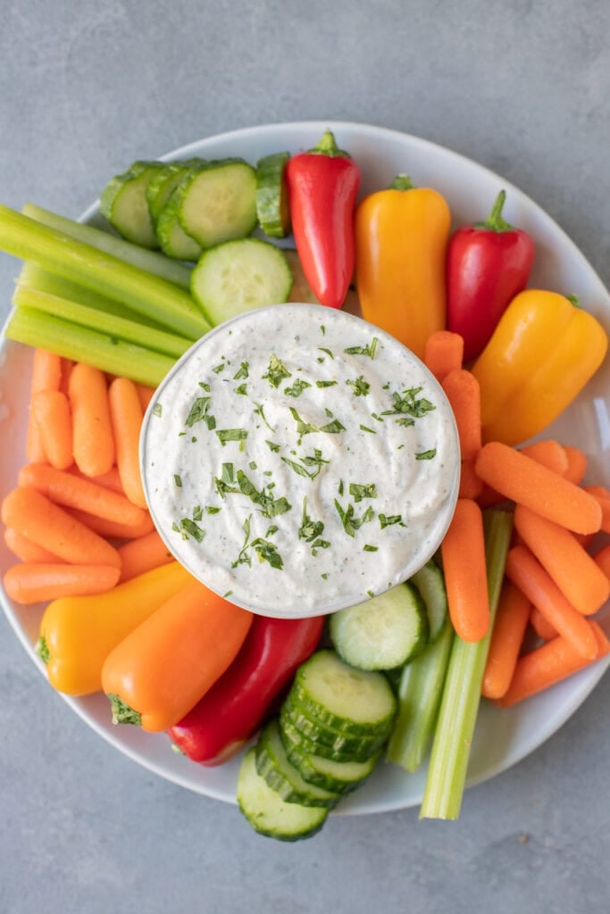 An overhead shot of greek yogurt veggie dip surrounded by veggies