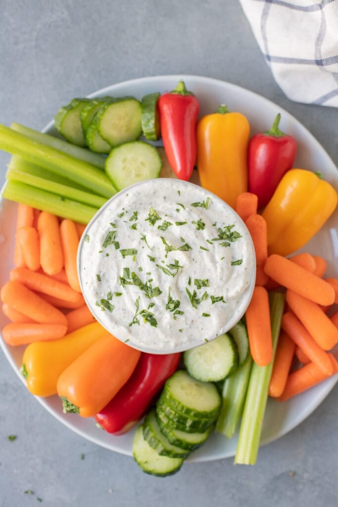 An overhead shot of greek yogurt veggie dip surrounded by veggies
